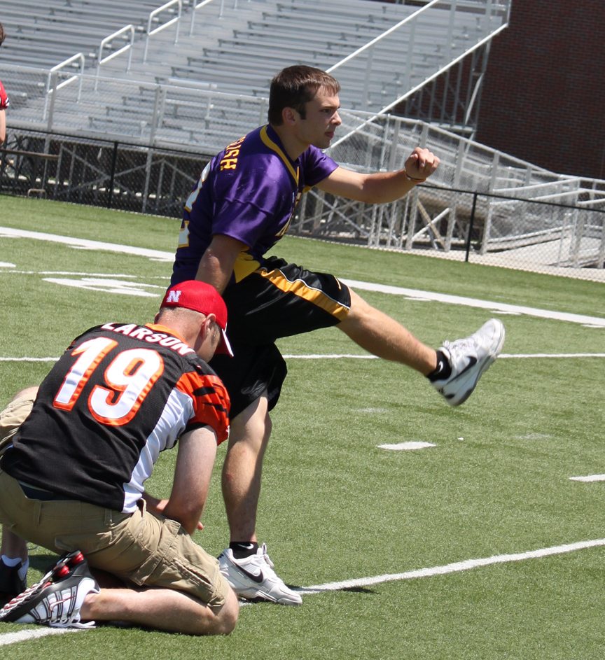 Lance English of Sumner kicks a football held by Kyle Larson at the 2011 Kicker's Kick-Off